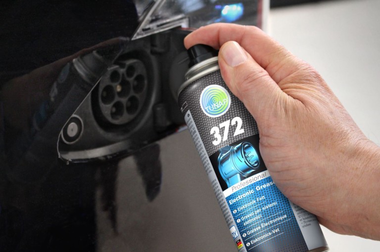 Elektric Line-anvendelse En person retter en sort spraydåse mod et elektrisk stik