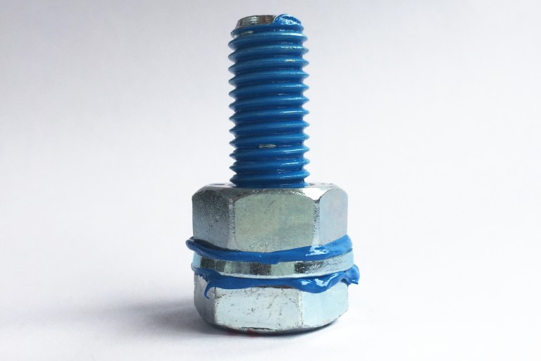 Schraubenmutter und Schraube geschmiert mit blauer Paste Schraubenmutter und Schraube geschmiert mit blauer Paste